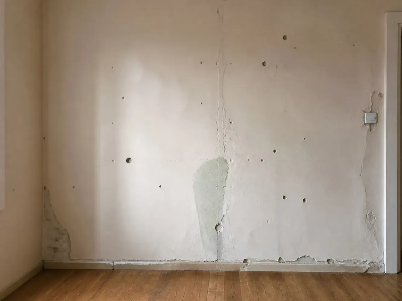 Beispiel: beschädigte Wand mit Rissen und Bohrlöchern